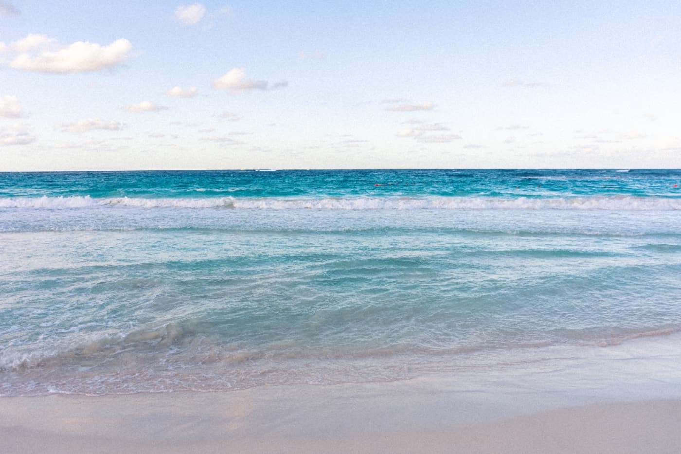 Mer turquoise et plage de sable clair sous un ciel bleu