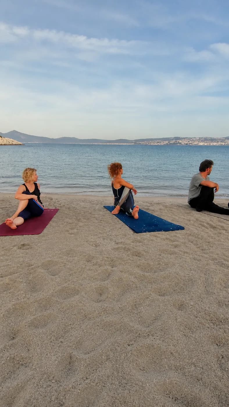 Cours de yoga en petit groupe face à la mer sur une plage de Marseille
