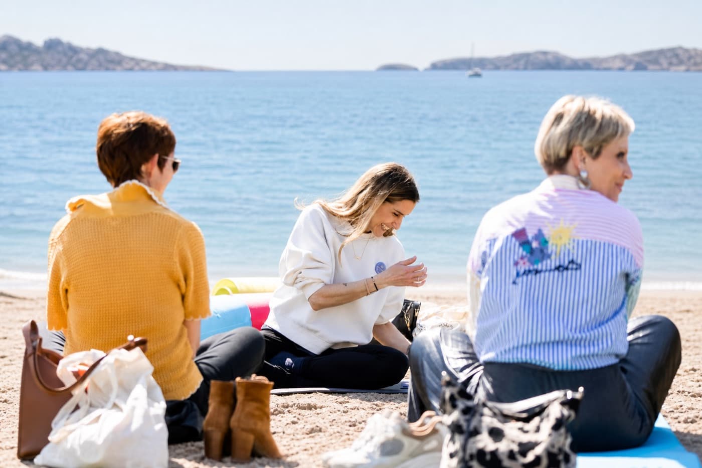 Groupe de participants en séance de respiration guidée sur une plage, assis face à la mer