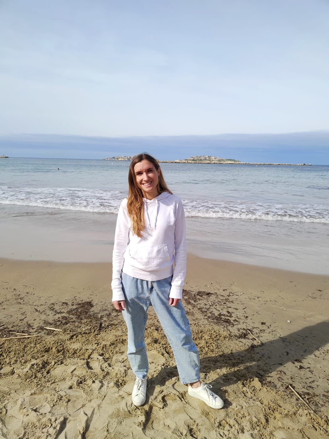 Virginia Philippe debout sur une plage de Marseille, face à la mer