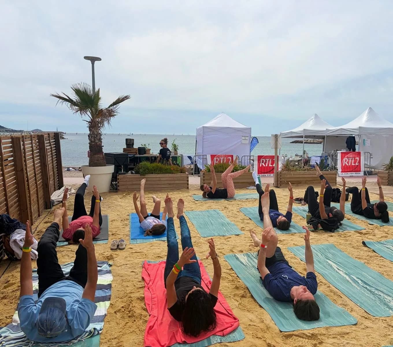 Grand cours collectif de Pilates sur la plage au bord de la mer