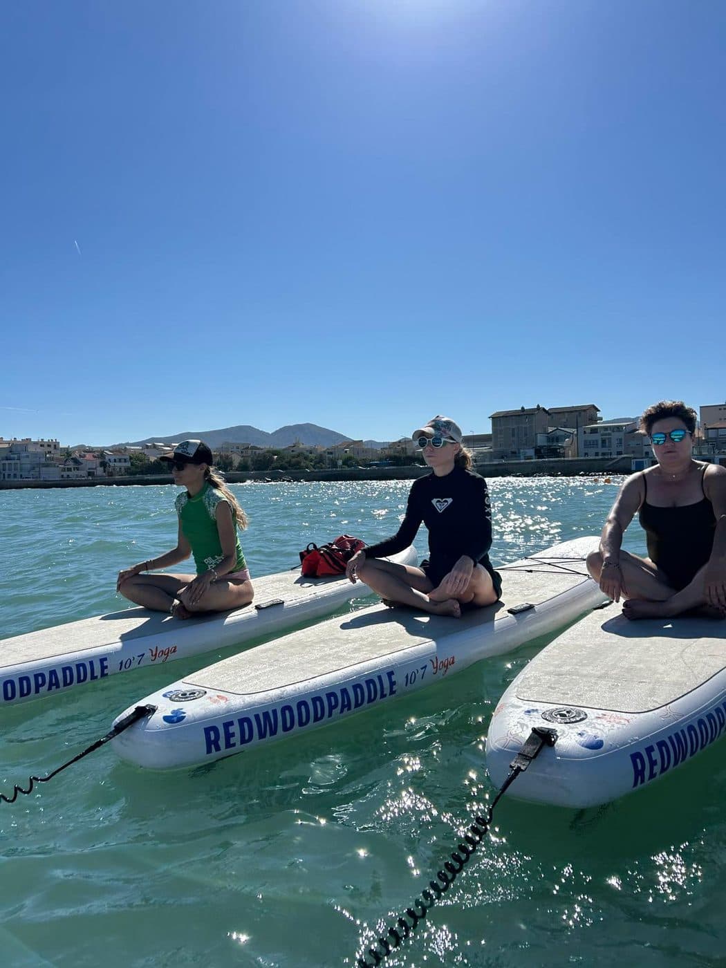 Virginia Philippe et deux participantes assises sur leurs paddles au large de Marseille